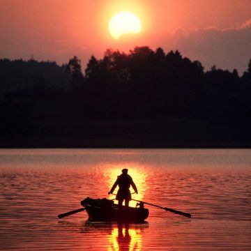 Ruderer bei Sonnenuntergang auf dem See