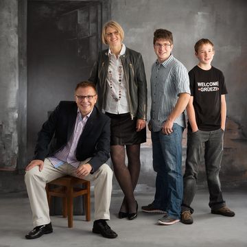 Studioaufnahme vor gemaltem Hintergrund und Holzstuhl